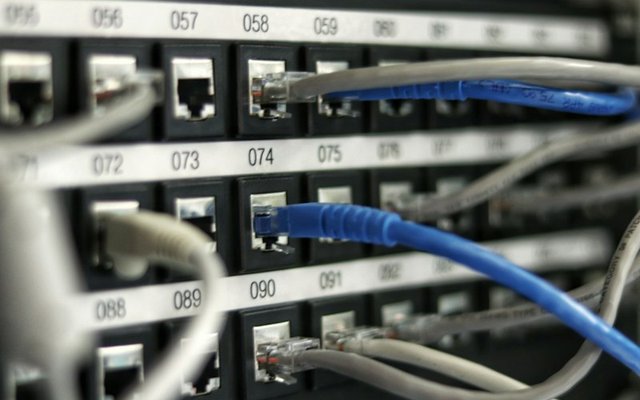 Certified network technician installing Cat6A structured cabling and patch panels